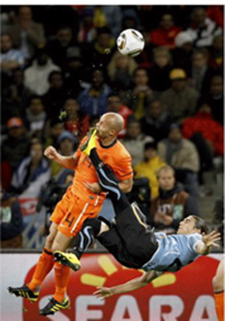 Die Aufnahme dieses Fouls des Uruquayers Martin Caceres am Niederländer Demy de Zeeuw im Weltmeisterschaftshalbfinale in Südafrika am 6. Juli 2010 brachte dem südafrikanischen Fotografen Mike Hutchings den ersten Preis in der Kategorie "Sport - Einzelfotos". (Foto: dpa)برنده بهترین عکس ورزشی مسابقه فوتبال هلند و اروگوئه که بازیکن هلندی از دهان مجروح میشود